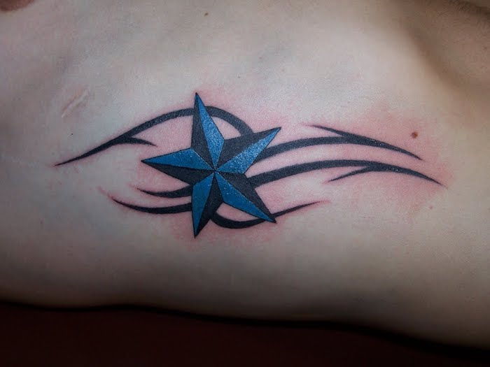 menneske med stjerne tatovering - en svart tatovering med en stor blå stjerne