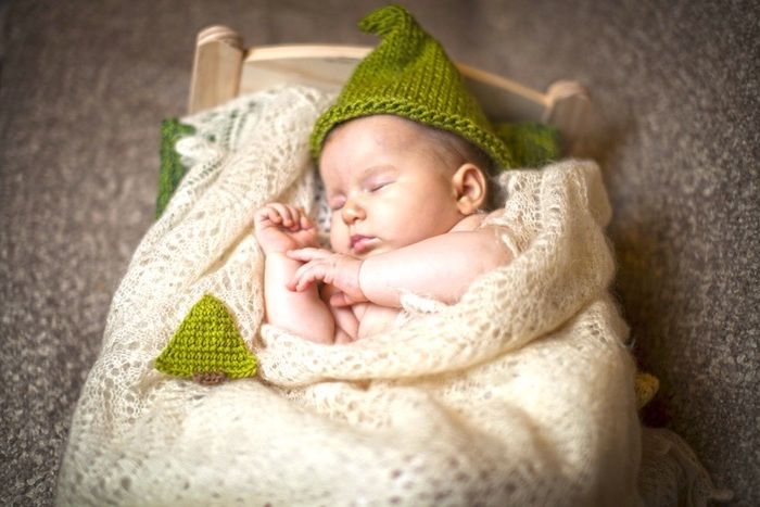 een aantal grappige welterustenfoto's - hier is een foto met een kleine slapende baba met een groene hoed en een klein bed