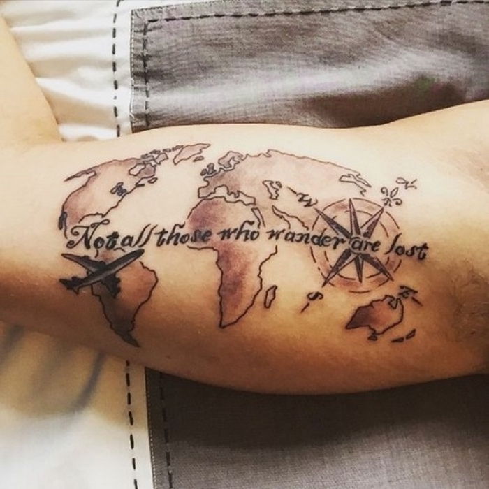 Mapa świata, mały czarny kompas i czarne nagłówki - pomysł na tatuaż kompasu na dłoni