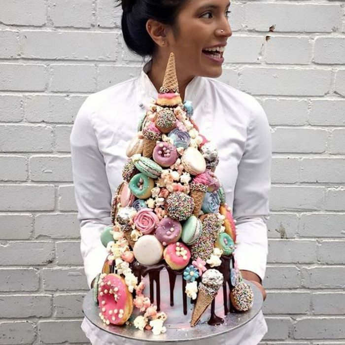 Uma garota com uma grande torta de unicórnio