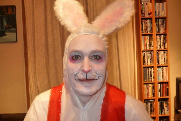 bir adam tavşan yüz makyaj kitap rafı arkasında
