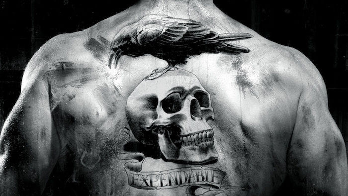 žmogus su tatuiruotėmis su juodu dideliu paukščiu ir dideliu baltu kaukoliu - tai reiškia kaukolės tatuiruotę