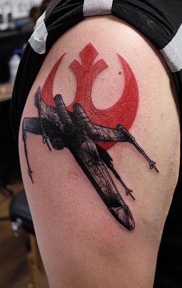 O mână care deține o război cu stele tatuaje mari, cu o navă de război cu stele neagră și un logo de război cu stele roșii