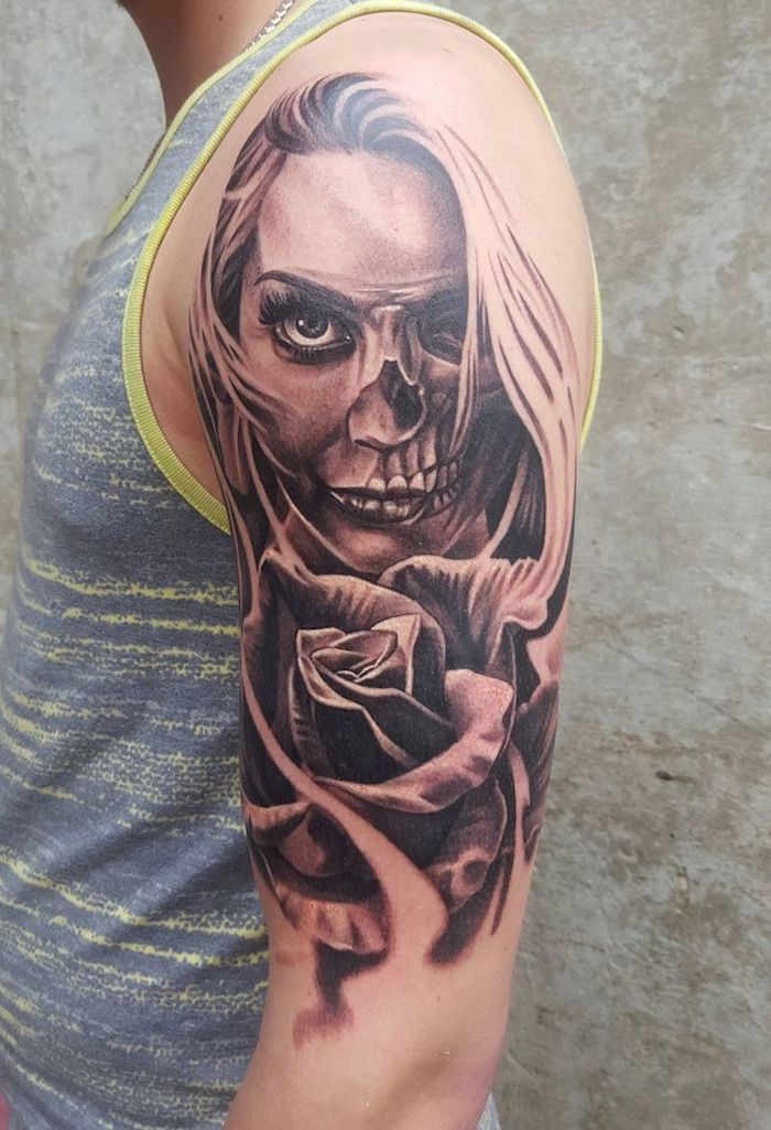Uomo con una mano che tiene un tatuaggio nero con una giovane donna e una grande rosa nera