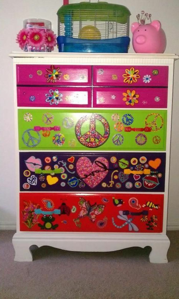 ett skåp dekorerat med färgglada servetter med hjärtan och blommor och fjärilar och sländor