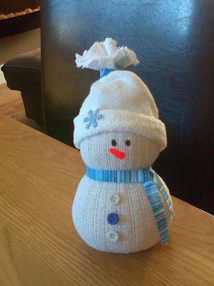 mali beli snežak z modrim šalom in tri vijolične in bele gumbe - snežaka iz nogavic