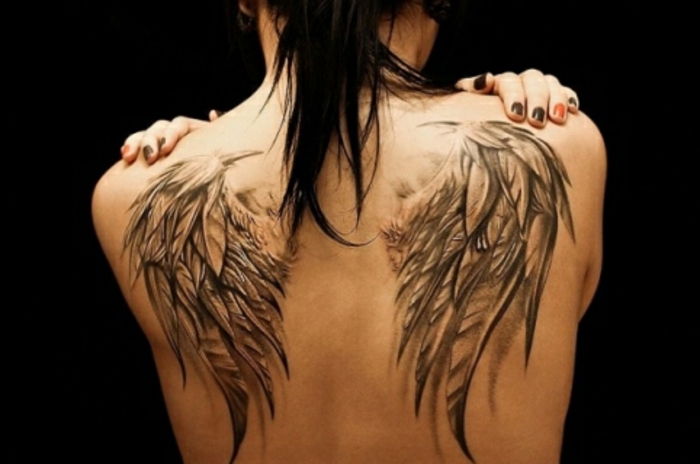 een vrouw met een grote engelenvleugel tattoo - hier zijn twee grote engelenvleugels met lange zwarte veren