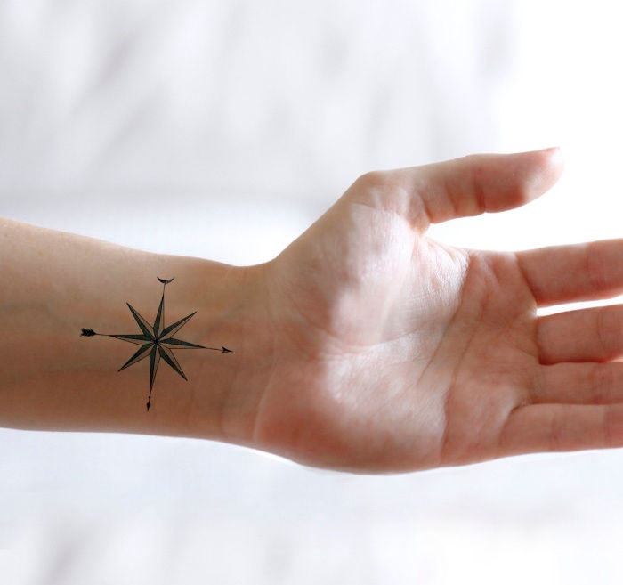 To jeden z najpiękniejszych tatuaży z małym czarnym kompasem na nadgarstku