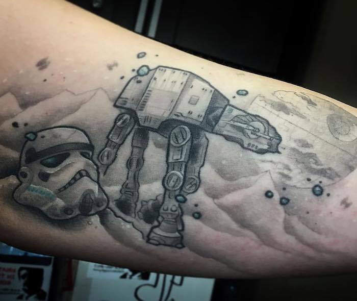 Mână cu un tatuaj războinic stele de stele, planete, munți. un robot mare și o clonă