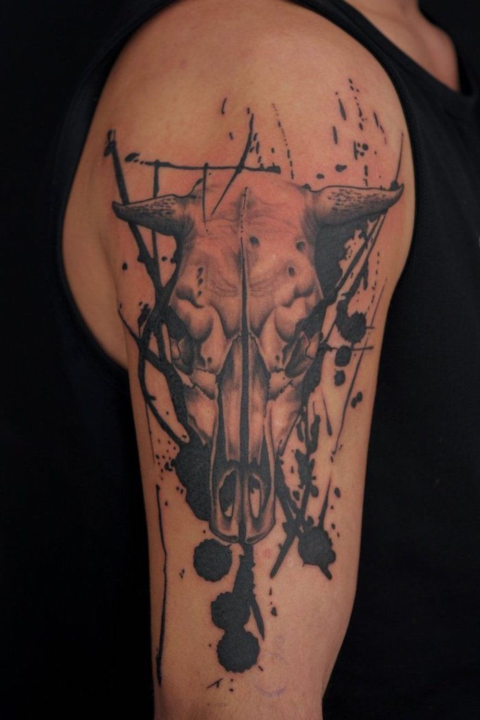 Ranka su tatuiruotė su baltos kaukolės gyvūno su juodais ragenais