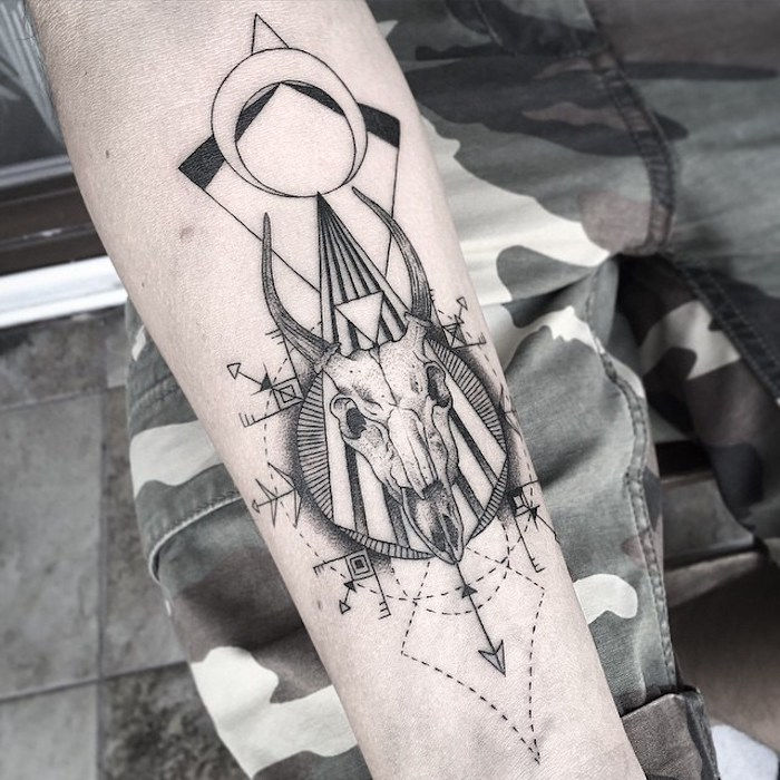 pomen tetovaže lobanje - roka s tetovažo z belo lobanjo živali z črnimi rogovi