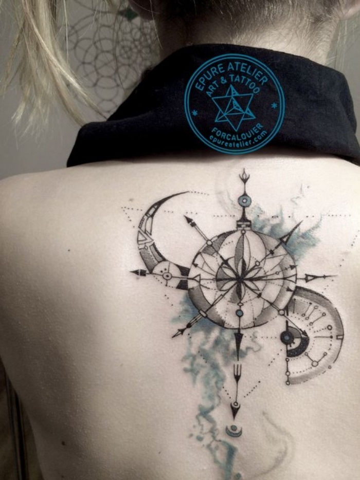 księżyc i czarny duży kompas steampunkowy - pomysł na kompasowy tatuaż na grzbiecie młodej kobiety
