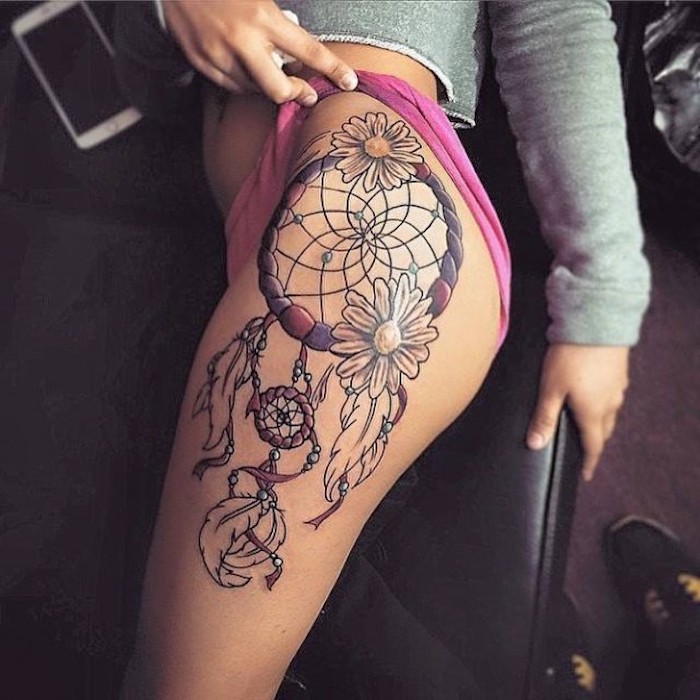 Ta en titt på denne tatoveringsideen med en drømfanger med to hvite blomster og hvite lange fjær - en tatovering for kvinner