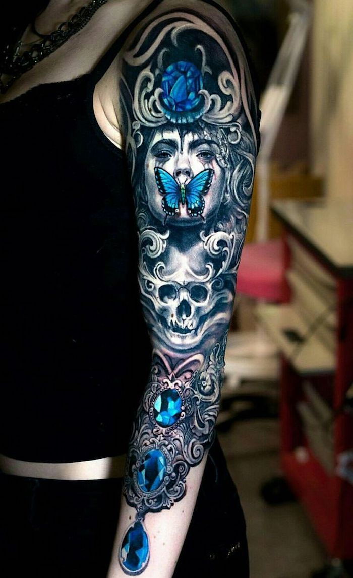 Ženska s tetovažo z belo lobanjo, modrim velikim diamantom in mlado ženo - lobanjo, ki pomeni tatoo