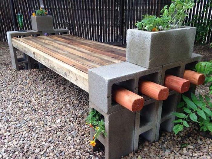 lavicu vyrobenú z dreva a so šedými veľkými kvetináčmi so zelenými rastlinami
