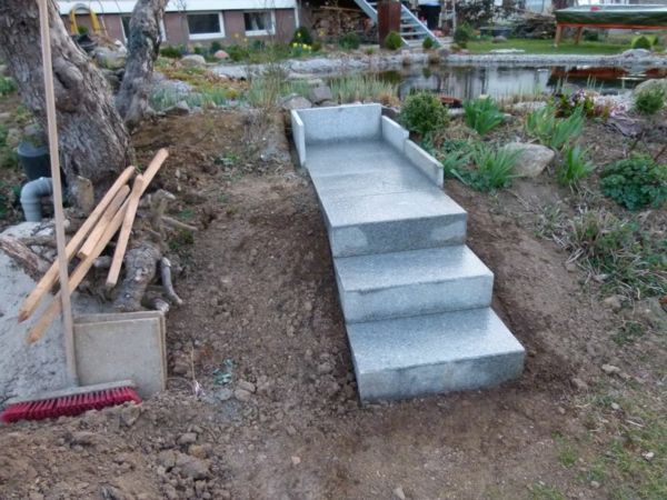 a-små trappor-självbyggd-i-process-bredvid en damm