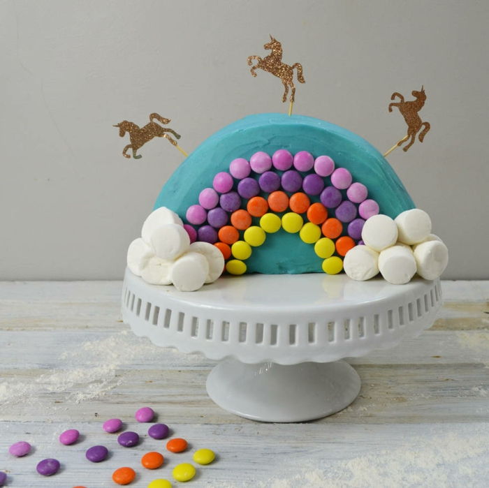 uma torta deliciosa com unicórnios e arco-íris