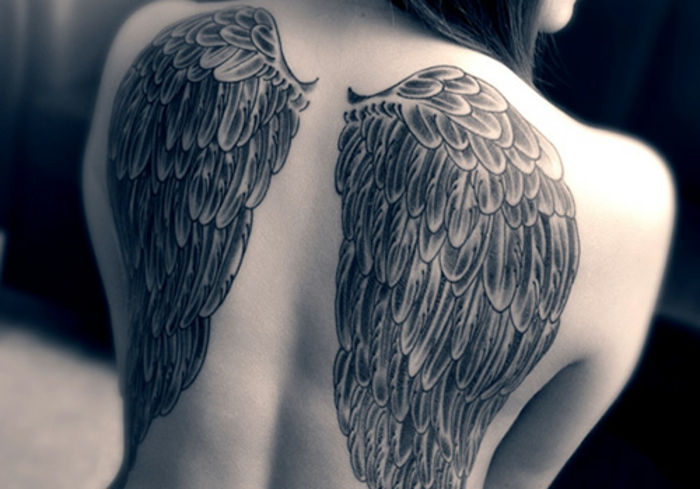 Oto kobieta z wielkim tatuażem anioła z długimi czarnymi skrzydłami anioła