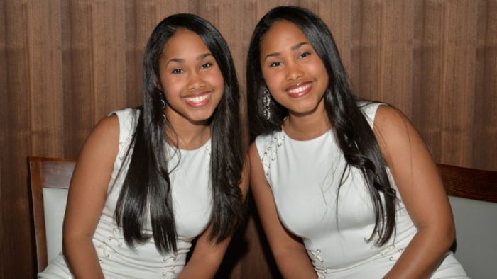 enäggstvillingar-Två unga-kvinnor klänningar med långa hår svart-white--