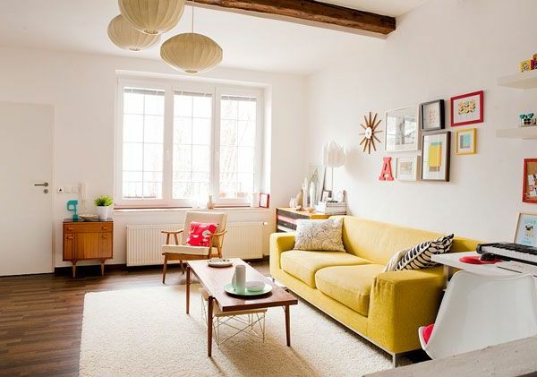 moderná obývacia izba so žltou pohovkou, guľaté lustre a dekoratívne predmety