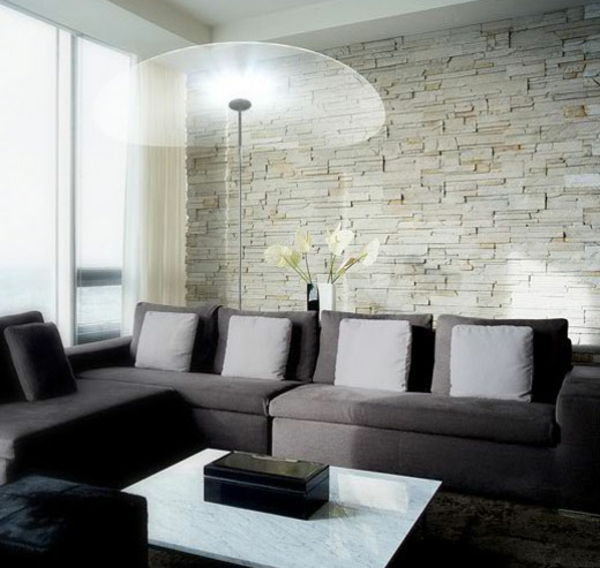 ett rum-vardagsrum tegelvägg och en soffa med grå kuddar