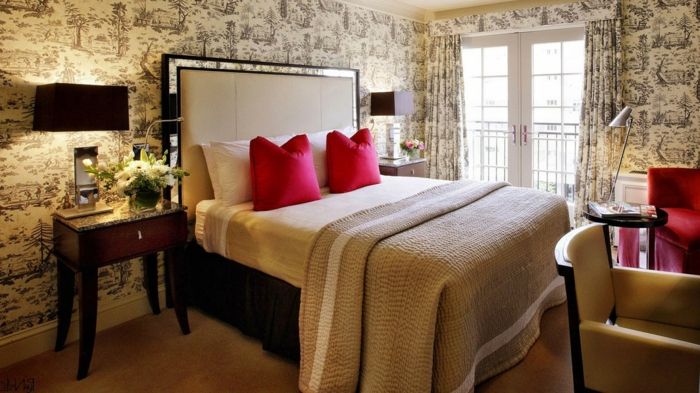 Elegantiškas miegamojo karaliaus dydžio lova ir raudonos pagalvės ir kėdės-derliaus tapetai užuolaidų su-the-pats modelis