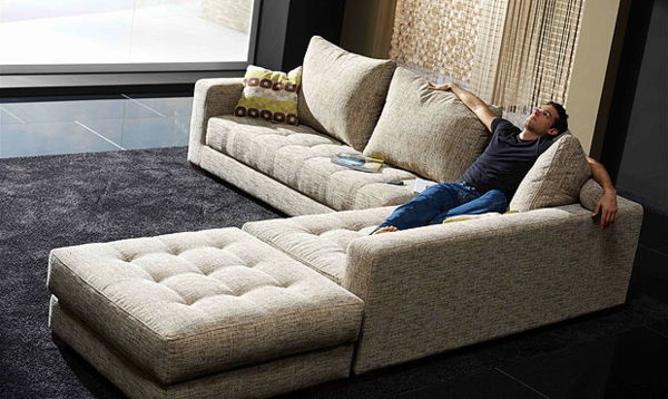 elegant-modell-av-sofa-i-hjemmekino-en ung mann sitter på den