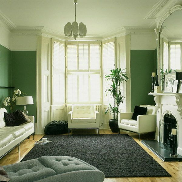 schema de culori pereți - nuanțe verzi - canapea cu pernă de aruncare și șemineu