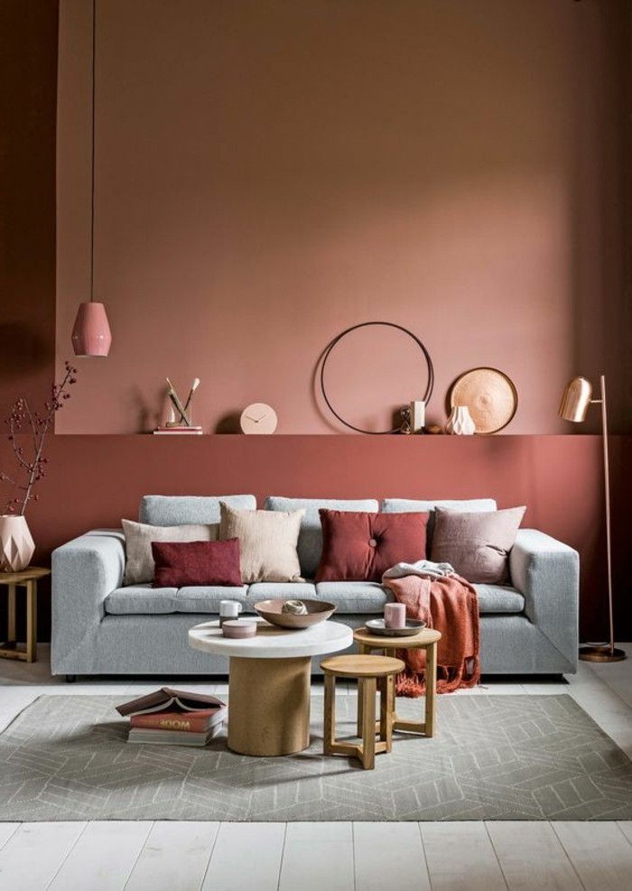 Barva oblikovanje stene opeke-stehlampe-zlato-stenske-ure-svetlo sivo-kavč-krog-les miza-vzorec preproga-ikebana vaza