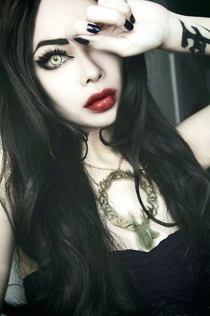 Garota gótica com maquiagem preta, cabelo longo ondulado, tingido de preto
