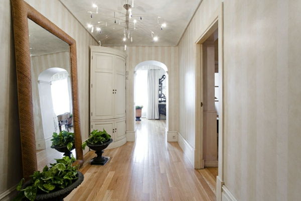 Dekorera korridor med vit tapeter - stor spegel och lyxkrona