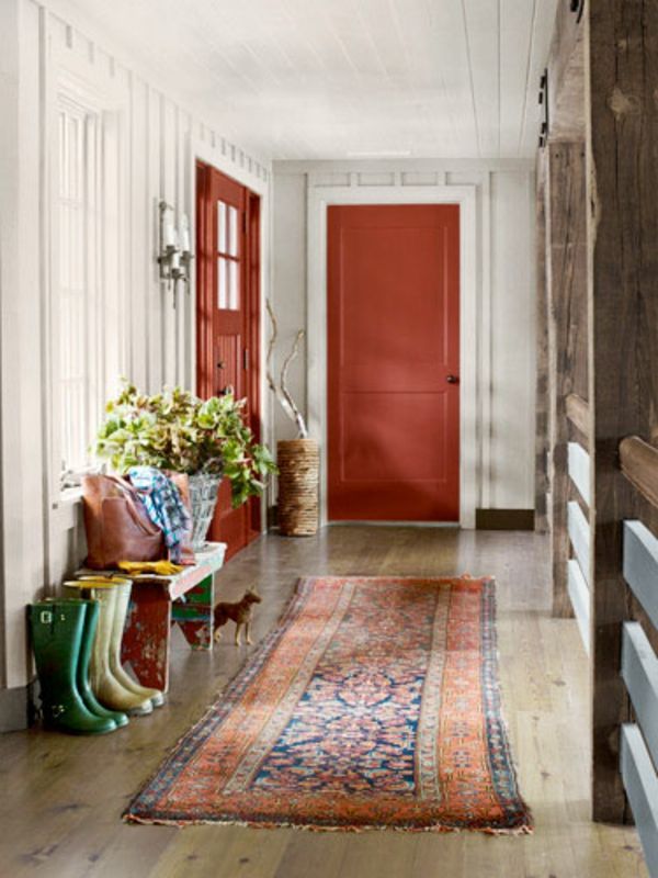liten hall med vit väggdesign och röda dörrar
