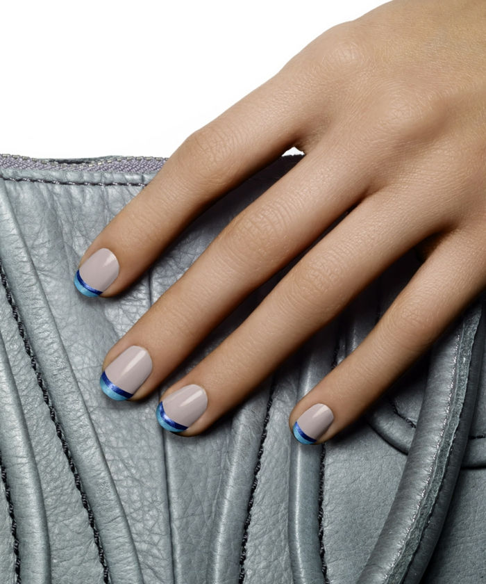 Fransk manikyr i blått och vitt, oval nagelform, grå läderväska som bakgrund
