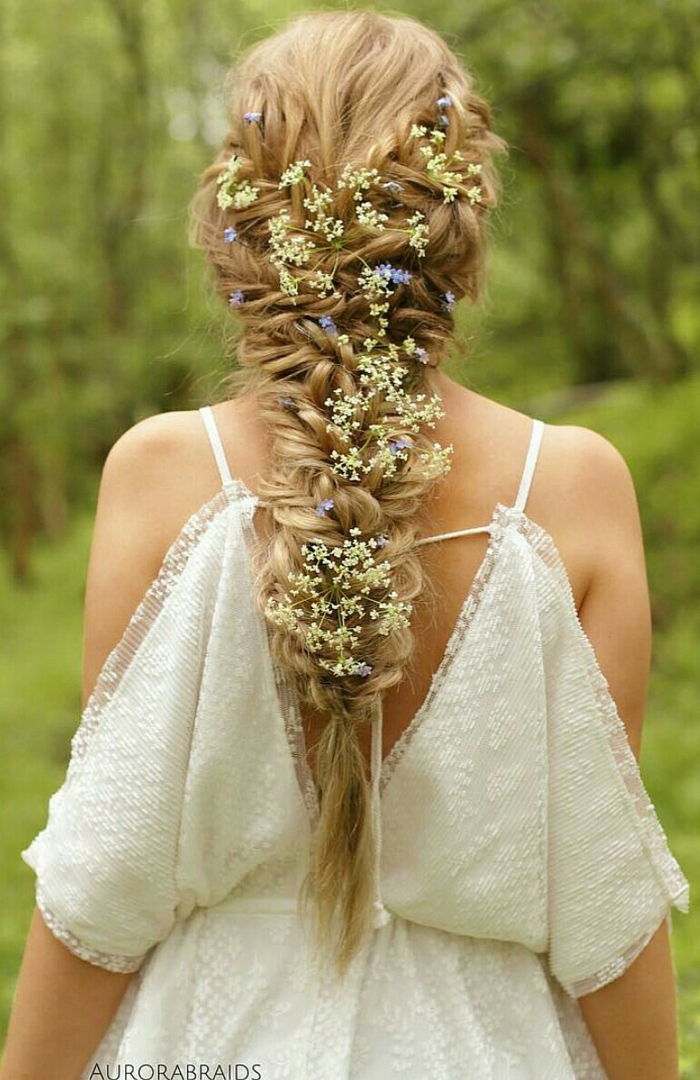 păr lung blond împletit cu flori proaspete împletite pentru o coafură perfectă