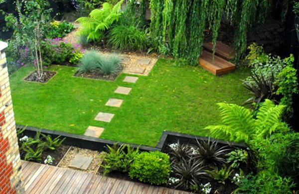 Kamienne płyty jako chodnik w pięknym zielonym ogrodzie