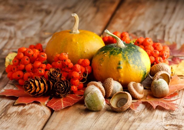 aranżacje jesiennych dekoracji, dynie, żołędzie, szyszki i jesienne liście, piękna dekoracja stołu