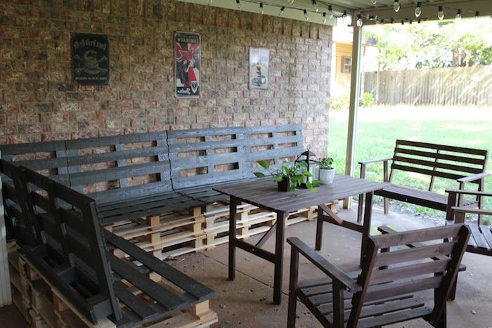 tuinideeën - een bruine houten tafel - stoelen en grote banken gemaakt van pallets - bouw je eigen tuinbank