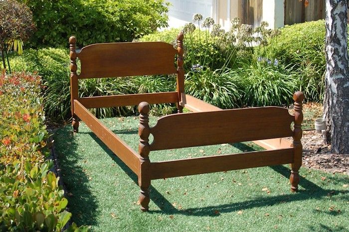 immagini di giardinaggio - un vecchio letto marrone per una panca da giardino marrone - giardino con piante verdi