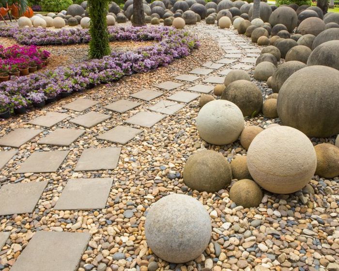 trädgårdsarbete med grus-sfäriska skulpturer - och blommor