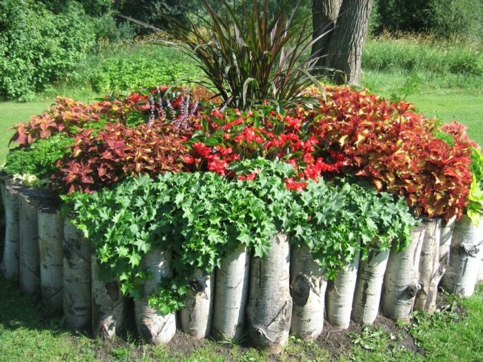 okrogli vrtnjak iz drevesnih cevk, poln rdečih cvetov - preprost oskrbniški vrt