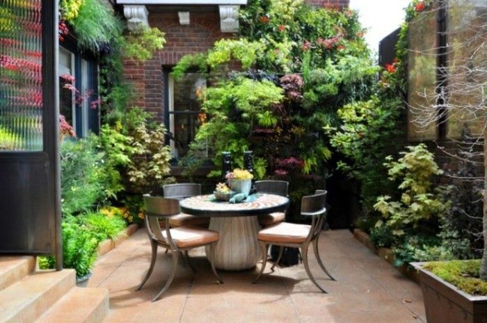 jardim ideias-para-pequeno-jardins-pequeno-round-table e-muitos verde de plantas