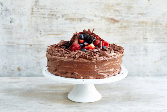 foto di torta di compleanno, torta decorata con cioccolato, lamponi e fragole