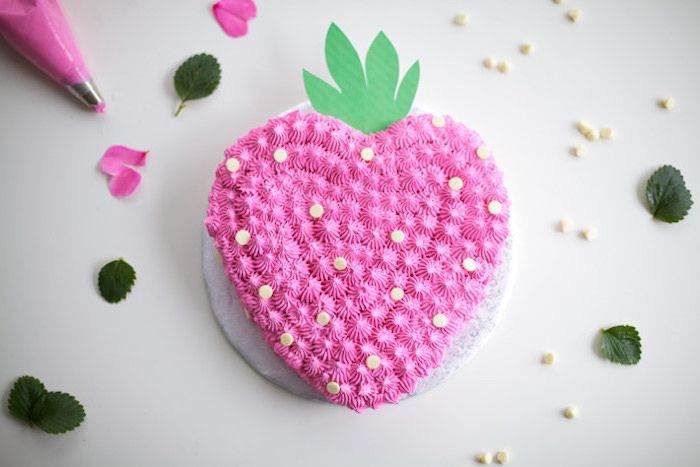 bursdagskake i form av hjerte dekorert med rosa krem