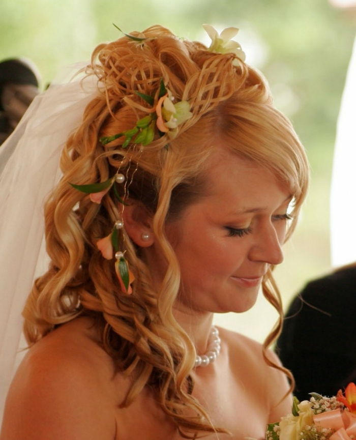 o mireasă cu coafura medievală - împletită lateral cu accesorii de păr pe părul blond