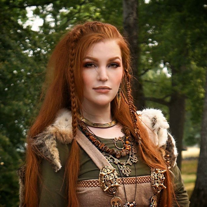 左右に編み上げられた髪型赤毛、中世の衣装、対応する小物