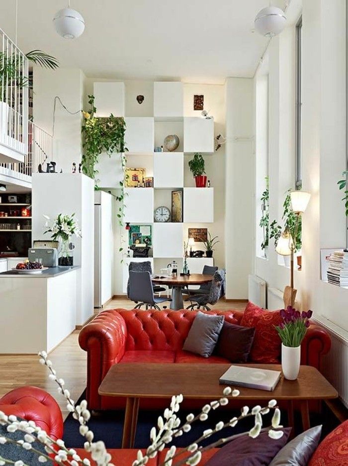 Dabartiniai interjero-balta-sienos-stilingi baldai ir raudonos odos sofa su mygtukais