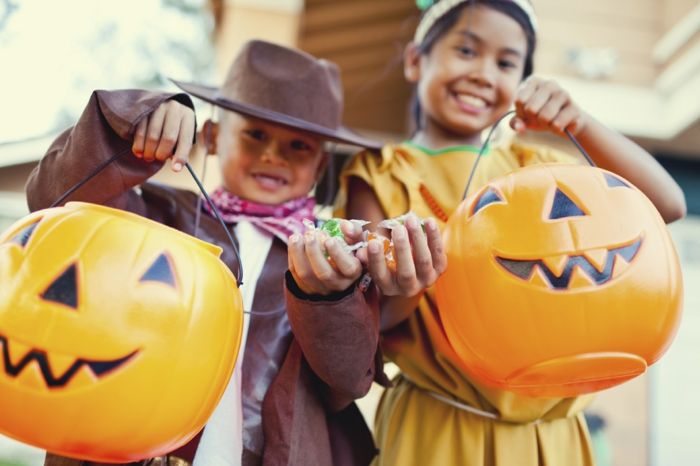 Samla godis, tjejer och pojke med stora Halloween kostymer, trick eller fest