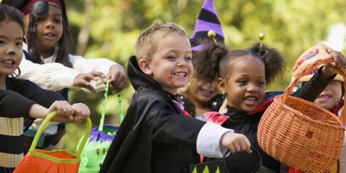 Små barn med Halloween kostymer, bin, pirater och trollkarlar, Trick or Treat, korgar för godis