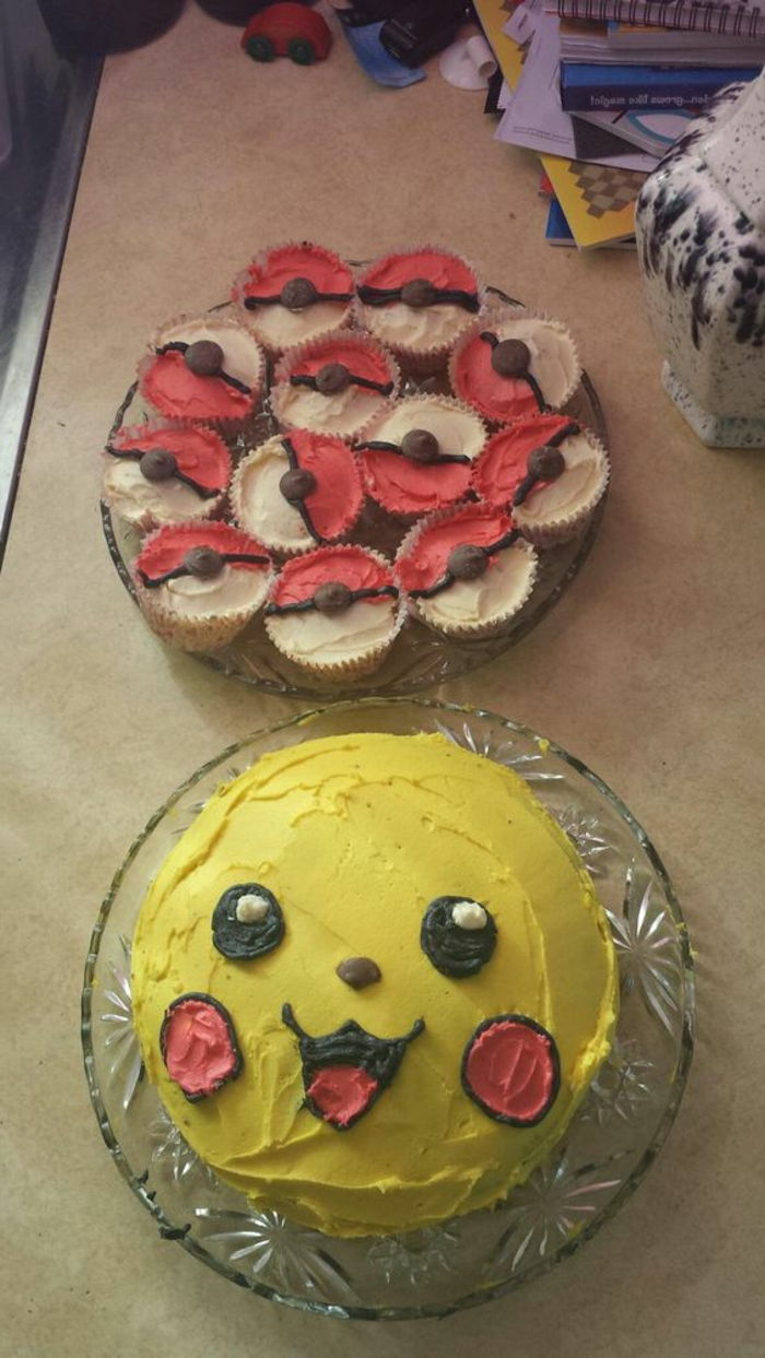 bolo de pokemon vermelho, pokeballs vermelhos, um grande bolo de pokemon amarelo, um pikachu de essência de pokemon amarelo com cozimento vermelho