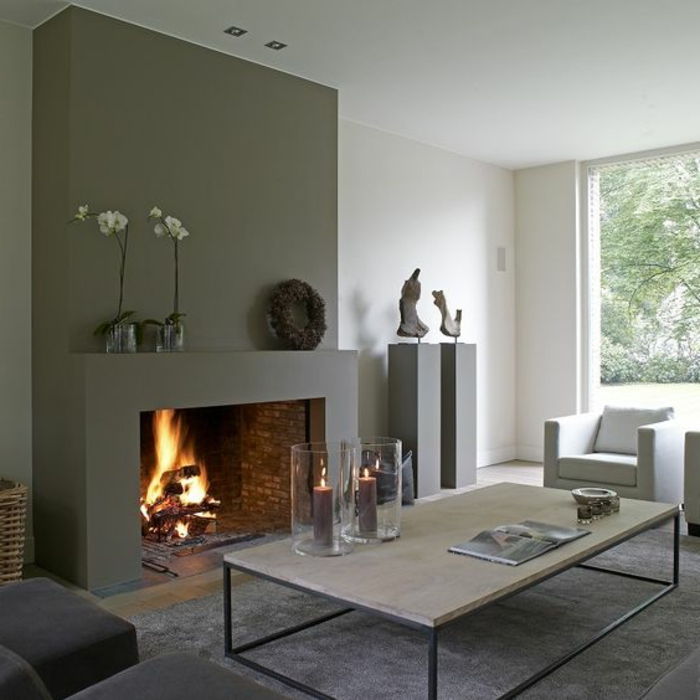 tegel öppen spis-grå vägg-white-wall-grå-möbel kerzendeko-grå-plysch mattan-designer soffbord
